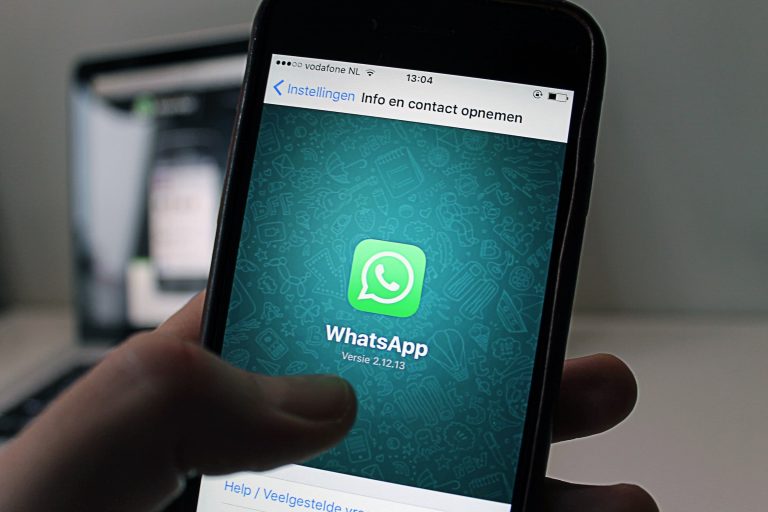 Hand met een smartphone waarop WhatsApp is geopend