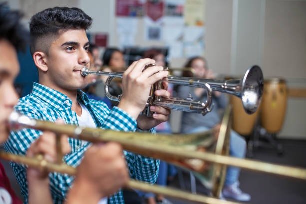 Jonge trompettist speelt mee tijdens de repetitie van het orkest
