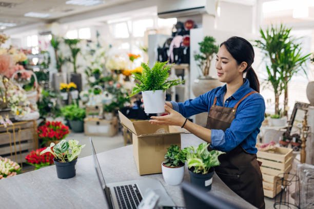 Bloemiste pakt een online bestelling met plantjes in een verzenddoos