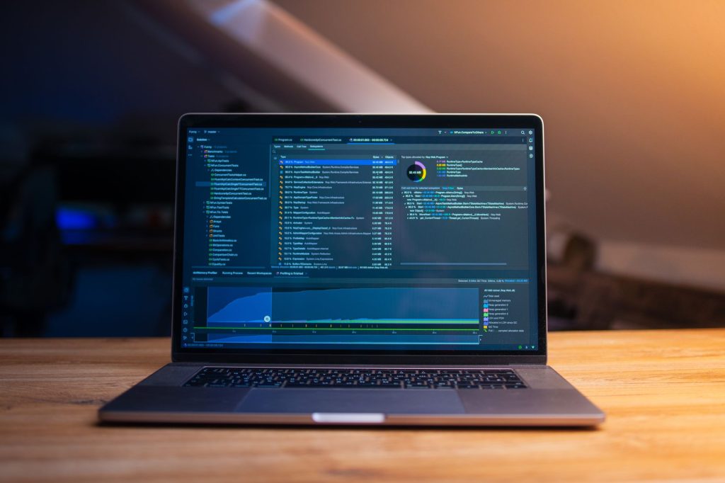 Laptop met programmeercode op het scherm in een donkere werkruimte